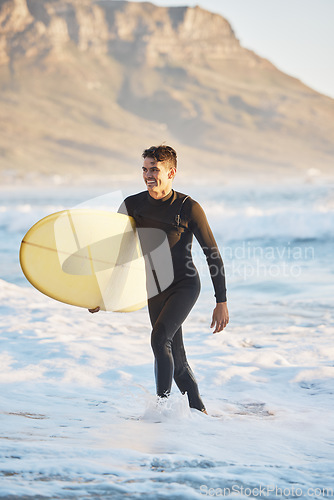 Image of Surfing sports and man walking from ocean with smile, surfboard in hand and happiness in summer. Nature, water sports and male surfer on beach shore after fitness, exercise and cardio for wellness