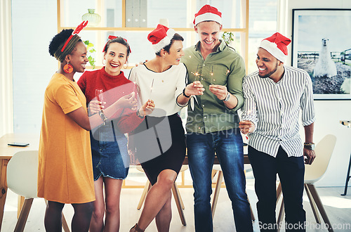 Image of Company Christmas party, staff and holiday celebration, corporate diversity and fun together at the office. Team with light sparklers, champagne and drinking to celebrate, group and happiness.