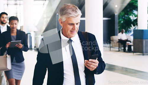 Image of Phone, senior and businessman walking to meeting, conference or workshop, texting and in office building. Corporate, boss and employee team check schedule, appointment and planning before tradeshow