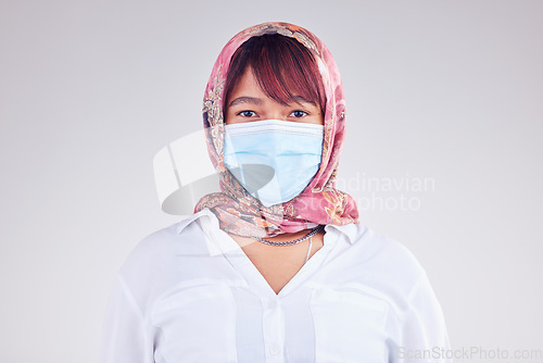 Image of Covid, muslim and mask with a woman in studio on a gray background for health, safety or new normal. Face, portrait and Islam with a female wearing a hijab during the corona virus pandemic