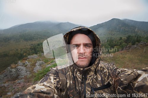 Image of Caucasian man in the mountain making selfie