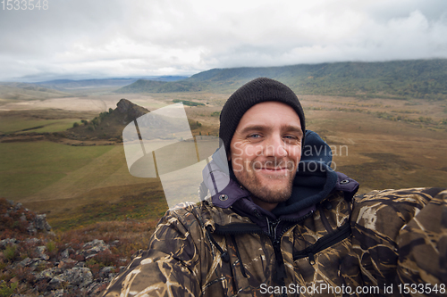 Image of Caucasian man in the mountain making selfie