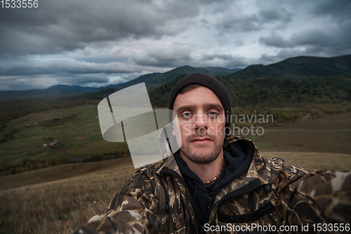 Image of Caucasian man in the mountain making selfie