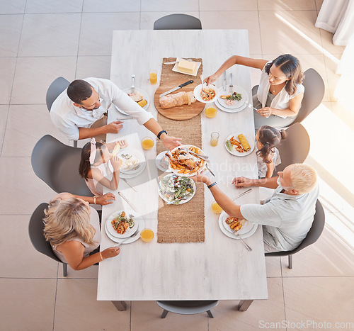 Image of Family, lunch and food at the table with big family bonding, sharing and eating together at the dining table. Meal, top view and family home with a mother, father and grandparents and kids eat