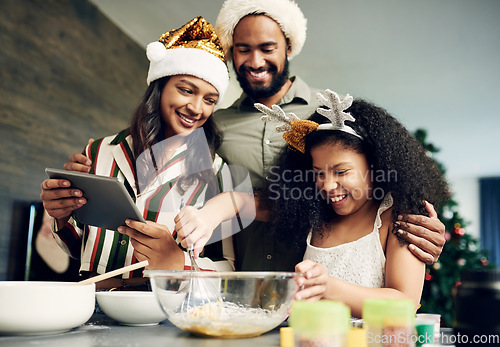 Image of Christmas, family and baking with a girl and parents mixing dough while using an online tablet recipe together. Food, children and kitchen with a mother, father and daughter learning to bake