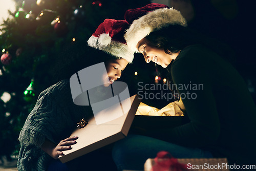 Image of Christmas, holiday and mother and girl with present opening magic gift box together for festive tradition. Family, love and mom with child on festival, celebration and vacation by Christmas tree