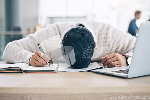 Image of Tired businessman, sleeping and desk on notebook from burnout or overworked at the office. Exhausted male employee asleep holding pen during writing, working or documents suffering from work fatigue