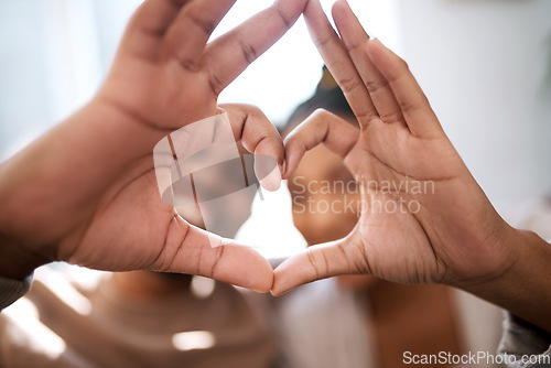 Image of Love, heart hands and happy black couple excited for future in new home with support, trust and commitment. Romance, heart hands with black man and black woman relax on honeymoon together.