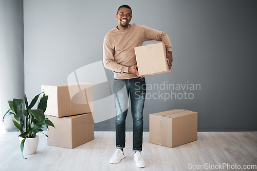 Image of Black man, moving and home portrait with box excited for real estate, property and new house. Boxes, happy and smile of home owner standing with cardboard boxes at gray wall advertising mockup.