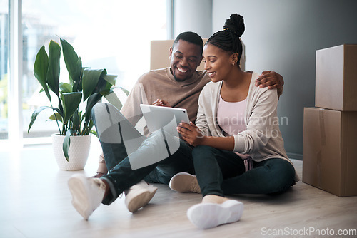 Image of African couple, real estate and tablet for new house interior shopping, property or relax on floor with boxes. Realtor, happy online communication and homeowners moving or packing apartment together