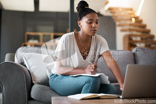 Image of Finance, laptop and black woman writing a house budget for bills, savings or money management on living room sofa. Paperwork, inflation and African person planning financial taxes payment in notebook