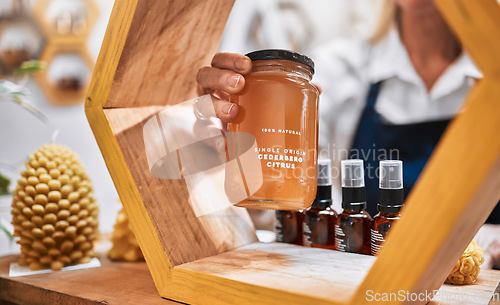 Image of Honey, product and retail with hands of woman and display shelf for grocery, natural and health food. Wellness, trader and organic with small business owner for sustainability, supermarket and store