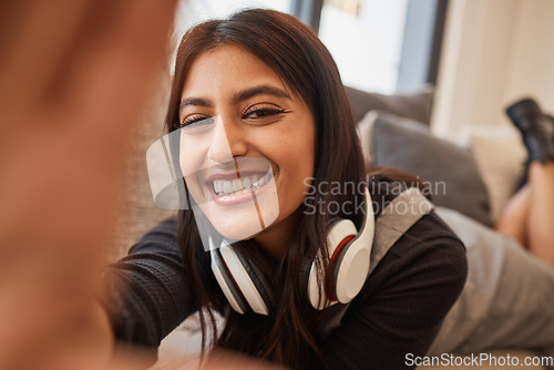 Image of Headphones, selfie and woman relax on sofa with virtual, video call or social media update and smile for holiday at home. Happy student or gen z girl with digital technology and photography portrait