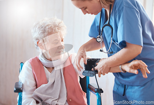 Image of Disability, monitor and old woman with a nurse for blood pressure check in a medical healthcare hospital. Wheelchair, doctor and caregiver helping a sick elderly person in a nursing home