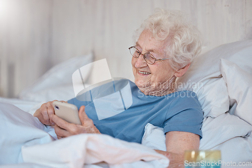 Image of Phone, bed and social media with a senior woman typing a text message while in the bedroom to relax. Contact, communication and mobile with a mature female reading or texting alone in the house