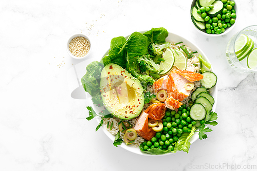 Image of Salmon avocado bowl with broccoli, green peas, rice and fresh salad. Healthy food, top view