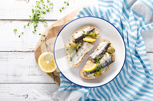 Image of Sardines sandwiches on a white wooden background. Mediterranean food. Top view