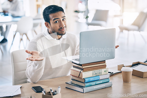 Image of Confused, laptop and multitask with a business man shrugging his shoulders while working in the office. Desk, question and doubt with a male employee multitasking while at work on a stack of books