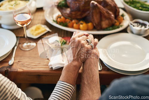 Image of Hands, pray and food with a senior couple sitting at a dining room table for a roast lunch together. Prayer, grace and holding hands with a mature man and woman eating, bonding or enjoying a meal