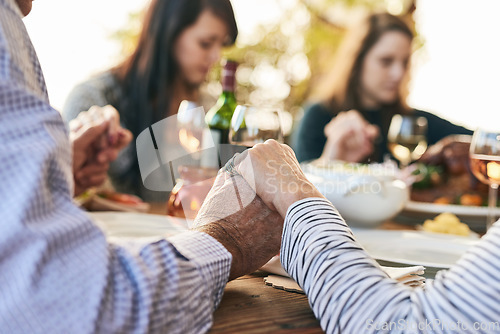 Image of Family, prayer and lunch for thanksgiving, celebration or party in garden, backyard or outdoor restaurant. Holding hands, mindfulness and gratitude for worship, god and praying with food on table