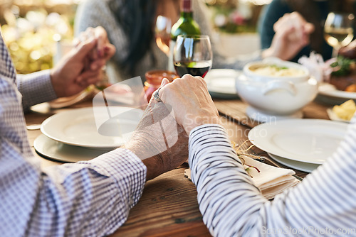 Image of Dinner, holding hands and family prayer at table for thanksgiving celebration with faith, religion and holiday gratitude. Love, social and hand holding of people praying for party, food and wine