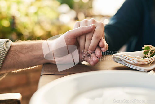 Image of Couple, holding hands and lunch with praying, love and trust in marriage, hope and care at table outdoor. Man, woman and hand for hope, gratitude and prayer in Christian faith, spiritual or support