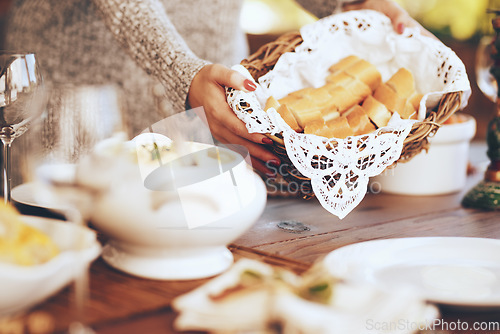 Image of Woman, bread basket and food at dinner table in home, house and dining room for family lunch, meal and hosting social gathering together. Closeup sliced baguette for party, celebration and eating