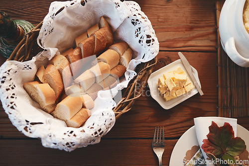 Image of Table, bread and butter for dinner, lunch or festive celebration for thanksgiving, christmas or birthday. Dining table, food and decoration for party in home, house or restaurant with basket for meal