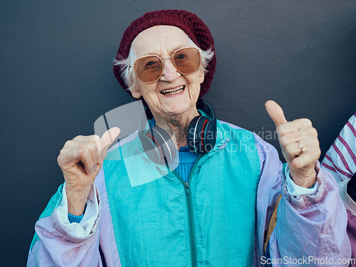 Image of Senior woman, thumbs up and headphones for stylish fashion, glasses or modern lifestyle and happiness freedom. Yes, hands and streaming music or portrait of happy, funky elderly person with smile
