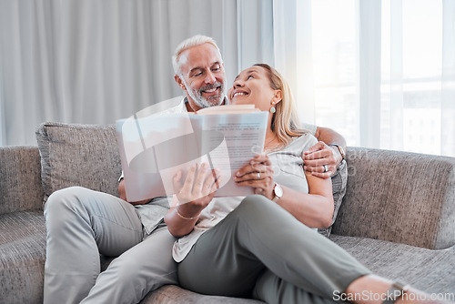 Image of Book, reading and relax with a senior couple sitting on a sofa in the living room of a home together. Books, love and storytelling with a mature man and woman enjoying a read while bonding in a house