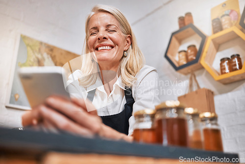 Image of Phone, sales and success with woman in store for honey, supermarket and natural grocery. Organic, health and wellness with small business owner and profit for retail, nutrition and vitamin products