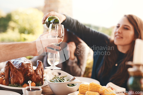 Image of Party, dinner and woman pouring wine in a wine glass to cheers at an outdoor celebration feast. Champagne, toast and girl serving a luxury alcohol drink at event in nature or backyard garden at home.