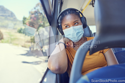 Image of Black woman, covid and mask with headphones in transport for safe traveling, trip or destination during pandemic. African American female in public transportation with face mask for health and safety