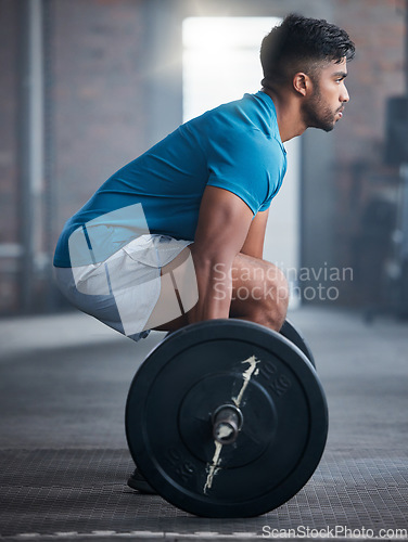 Image of Fitness, deadlift and man in gym in a workout, exercise or strength training for strong powerful legs and core. Focus, wellness and healthy Indian sports bodybuilder weightlifting a heavy barbell