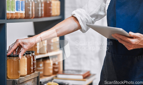 Image of Hands, tablet and honey jar for inventory check, inspection or pricing at the workplace. Hand of small business owner doing inspection working with touchscreen for product checking at the store