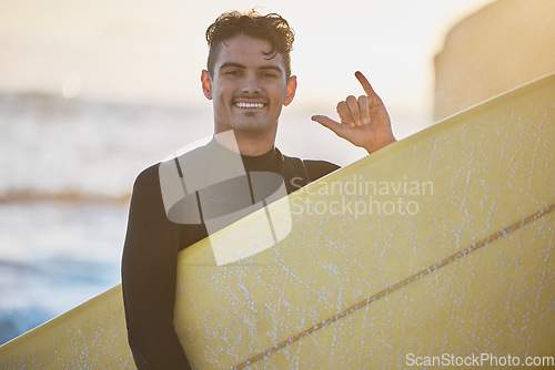 Image of Man, surfer and shaka in beach portrait with surfboard, smile or hang loose sign in outdoor sunshine. Happy, ocean and guy with hang ten hand, summer sunset or surfing by sea for water sport exercise