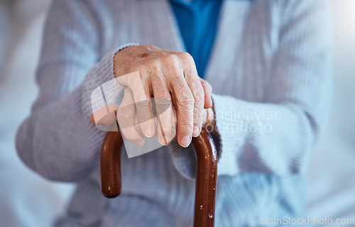 Image of Hands, cane and disability with a senior woman closeup in her home alone with a walking stick for mobility. Health, medical and wellness with a mature female in a retirement home with hand wrinkles