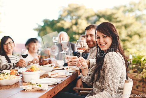 Image of Toast, wine and family at lunch in a garden during a Christmas party on the patio. Food, alcohol and portrait of friends with a cheers and eating at a table during a celebration in a backyard