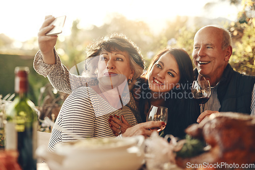 Image of Family, phone selfie and happy thanksgiving, lunch and happy with wine, glass and social media photo in home. Senior mother, father and daughter smile, love and together for picture, alcohol and care