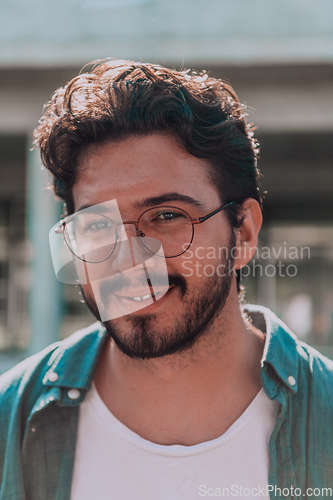 Image of A portrait of a modern man, exuding confidence and style, against an outdoor backdrop, showcasing his charisma and fashionable demeanor.