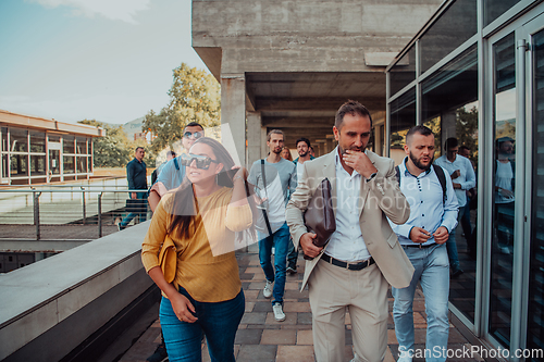 Image of A diverse group of businessmen and colleagues walking together by their workplace, showcasing collaboration and teamwork in the company.