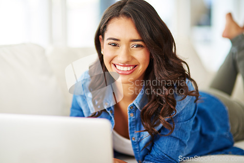 Image of Woman portrait, laptop and relax on sofa, social media or type blog, website and email on internet in living room. Computer, remote work and technology with a happy female working on the sofa in home