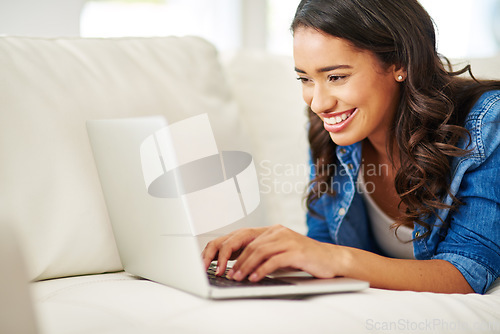 Image of Laptop, black woman on laying on sofa writing email, checking social media or streaming movie at home. Weekend, woman on couch with computer and relax on break in living room surfing the internet.