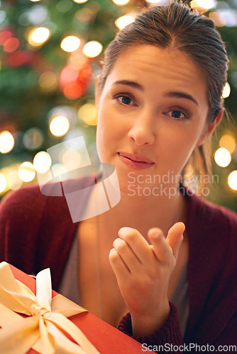 Image of Christmas, gift and woman pointing at choice or person to give present for Christian religion holiday celebration with a Christmas tree. Portrait of female at home with giftbox for giving background