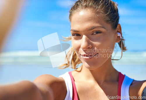 Image of Selfie, beach and fitness with a sports woman listening to music during her exercise workout outdoor in nature. Portrait, health and wellness with a female athlete training by the sea or ocean