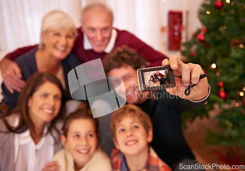 Image of Happy, family, camera and selfie in living room for christmas, bonding and relax in their home together. Happy family, photography and generations embrace and pose for festive picture, happy and joy