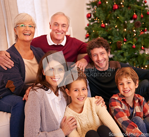 Image of Christmas, happy and portrait of family on sofa for festive, celebration and holiday cheer. Support, relax and smile with people in living room at home for gift giving, xmas and gratitude together