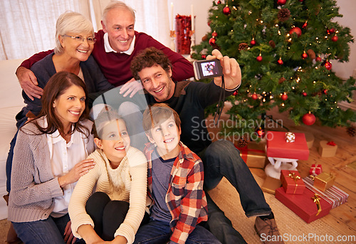 Image of Family, christmas party and phone selfie, festive season or holiday celebration. Portrait, smile and grandparents, kids and parents celebrate, picture pose or photo smile for memory together in home