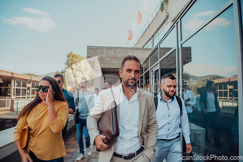 Image of A diverse group of businessmen and colleagues walking together by their workplace, showcasing collaboration and teamwork in the company.