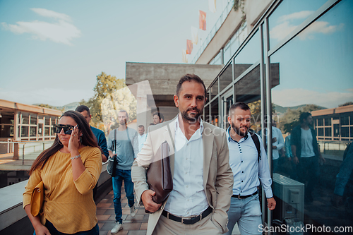 Image of A diverse group of businessmen and colleagues walking together by their workplace, showcasing collaboration and teamwork in the company.